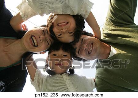 Close-up of a mid adult couple and their two daughters forming a circle View Large Photo Image Stock Photography - Close-up of a mid adult couple and their two daughters forming a circle. Fotosearch