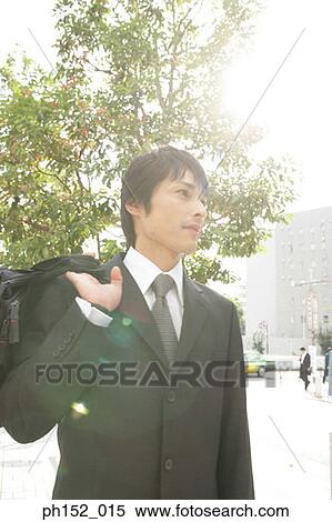 Close-up of a mid adult man carrying a hand bag View Large Photo Image Stock Photography - Close-up of a mid adult man carrying a hand bag. Fotosearch