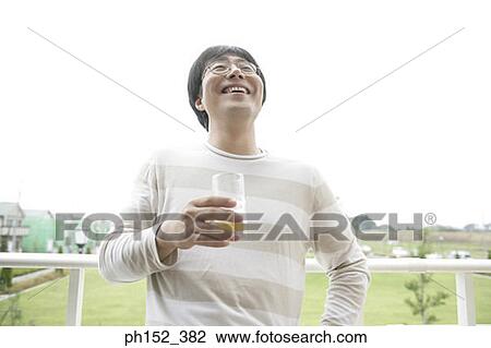 Close-up of a mid adult man holding a glass of wine View Large Photo Image Stock Image - Close-up of a mid adult man holding a glass of wine. Fotosearch