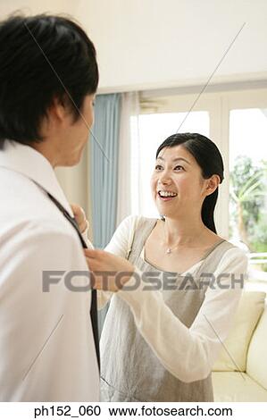 Close-up of a mid adult woman adjusting a mid adult man's tie View Large Photo Image Stock Image - Close-up of a mid adult woman adjusting a mid adult man's tie. Fotosearch
