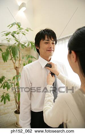 Close-up of a mid adult woman adjusting a mid adult man's tie View Large Photo Image Stock Image - Close-up of a mid adult woman adjusting a mid adult man's tie. Fotosearch