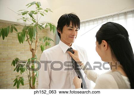 Close-up of a mid adult woman adjusting a mid adult man's tie View Large Photo Image Stock Image - Close-up of a mid adult woman adjusting a mid adult man's tie. Fotosearch