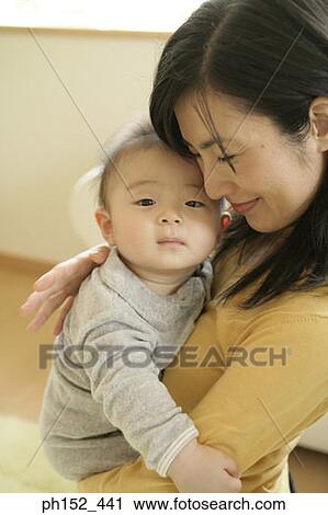 Close-up of a mid adult woman carrying her son View Large Photo Image Stock Image - Close-up of a mid adult woman carrying her son. Fotosearch