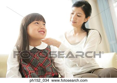 Close-up of a mid adult woman combing her daughter's hair View Large Photo Image Picture - Close-up of a mid adult woman combing her daughter's hair. Fotosearch