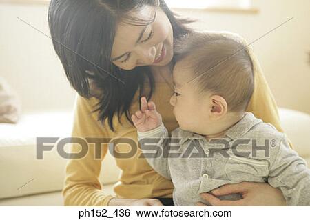 Close-up of a mid adult woman holding her son View Large Photo Image Stock Photograph - Close-up of a mid adult woman holding her son. Fotosearch