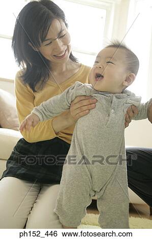 Close-up of a mid adult woman holding her son View Large Photo Image Stock Photograph - Close-up of a mid adult woman holding her son. Fotosearch
