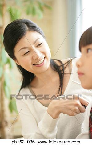 Close-up of a mid adult woman looking at her daughter and smiling View Large Photo Image Stock Photograph - Close-up of a mid adult woman looking at her daughter and smiling. Fotosearch