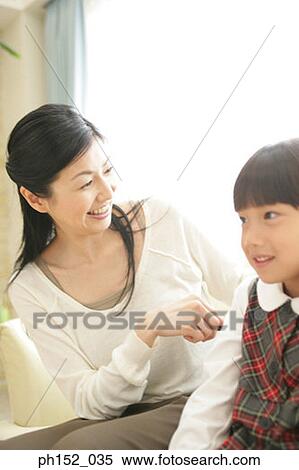 Close-up of a mid adult woman looking at her daughter's hair View Large Photo Image Stock Photography - Close-up of a mid adult woman looking at her daughter's hair. Fotosearch