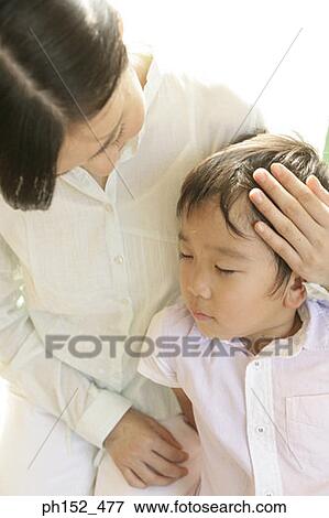 Close-up of a mid adult woman sitting with her son View Large Photo Image Stock Photo - Close-up of a mid adult woman sitting with her son. Fotosearch