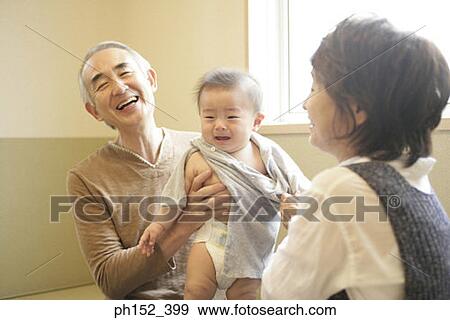 Close-up of a senior couple dressing their grandson View Large Photo Image Stock Photo - Close-up of a senior couple dressing their grandson. Fotosearch