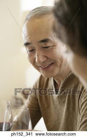 Close-up of a senior couple holding glasses of red wine View Large Photo Image Stock Image - Close-up of a senior couple holding glasses of red wine. Fotosearch