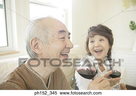 Close-up of a senior couple holding glasses of red wine and laughing View Large Photo Image Stock Photography - Close-up of a senior couple holding glasses of red wine and laughing. Fotosearch