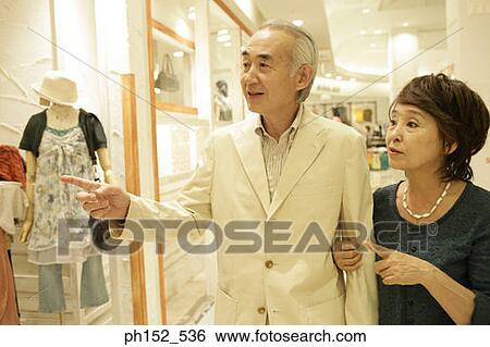 Close-up of a senior couple pointing towards a window display in a shopping mall View Large Photo Image Stock Photograph - Close-up of a senior couple pointing towards a window display in a shopping mall. Fotosearch