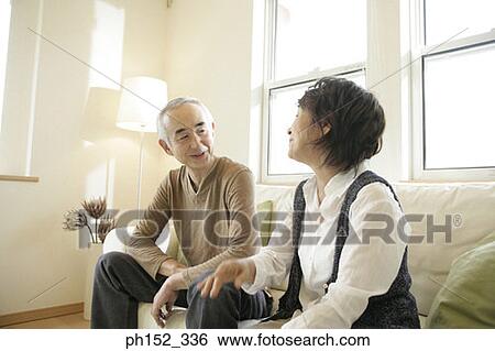 Close-up of a senior couple sitting on a couch and smiling View Large Photo Image Stock Photograph - Close-up of a senior couple sitting on a couch and smiling. Fotosearch