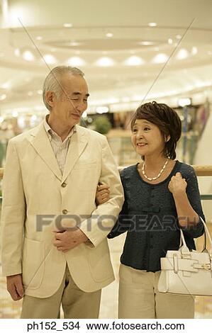 Close-up of a senior couple smiling in a shopping mall View Large Photo Image Picture - Close-up of a senior couple smiling in a shopping mall. Fotosearch