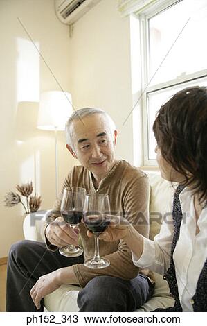 Close-up of a senior couple toasting with glasses of red wine View Large Photo Image Stock Image - Close-up of a senior couple toasting with glasses of red wine. Fotosearch
