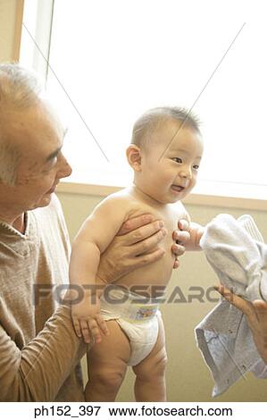Stock Photo - Close-up of a senior man holding his grandson. Fotosearch