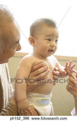 Close-up of a senior man holding his grandson View Large Photo Image Stock Photograph - Close-up of a senior man holding his grandson. Fotosearch
