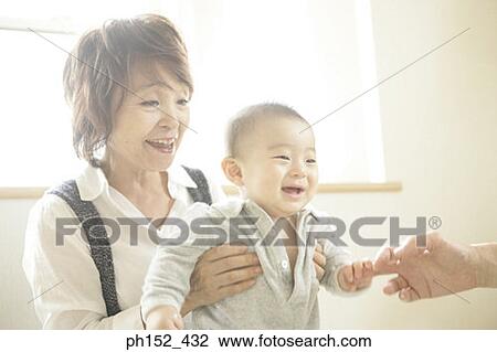 Close-up of a senior woman and her grandson holding a person's finger View Large Photo Image Stock Image - Close-up of a senior woman and her grandson holding a person's finger. Fotosearch