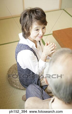 Picture - Close-up of a senior woman praying in front of a senior man. Fotosearch
