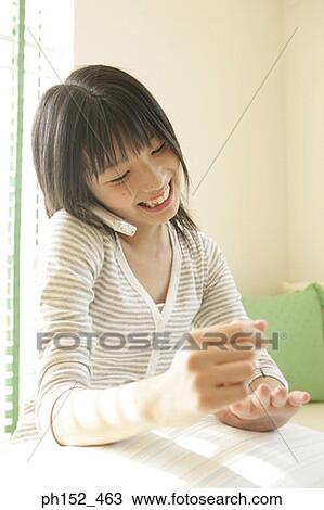 Close-up of a young woman talking on a mobile phone and applying nail polish on her fingernails View Large Photo Image Stock Image - Close-up of a young woman talking on a mobile phone and applying nail polish on her fingernails. Fotosearch