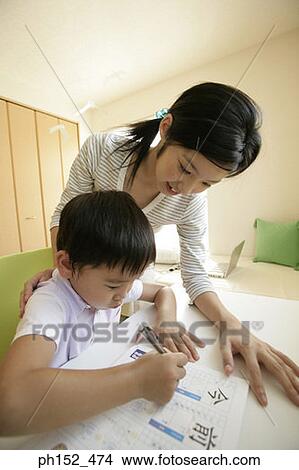 Close-up of a young woman teaching her brother View Large Photo Image Picture - Close-up of a young woman teaching her brother. Fotosearch