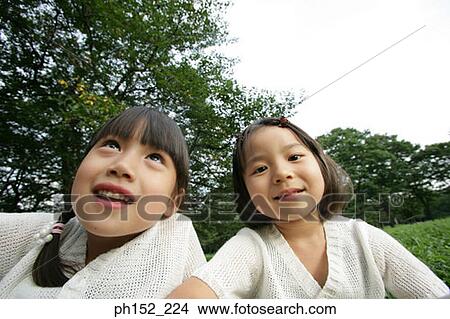 Close-up of two girls in a park View Large Photo Image Picture - Close-up of two girls in a park. Fotosearch