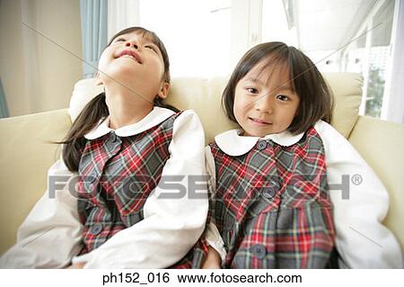 Close-up of two girls sitting on a couch View Large Photo Image Stock Photograph - Close-up of two girls sitting on a couch. Fotosearch
