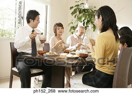 Stock Photo - Family sitting at the dining table. Fotosearch