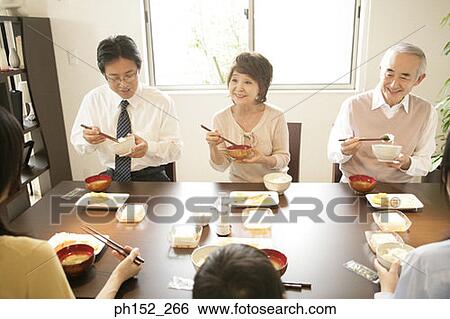 Family sitting at the dining table View Large Photo Image Stock Photograph - Family sitting at the dining table. Fotosearch