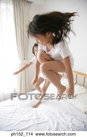 Girl and her sister jumping on the bed View Large Photo Image Picture - Girl and her sister jumping on the bed. Fotosearch
