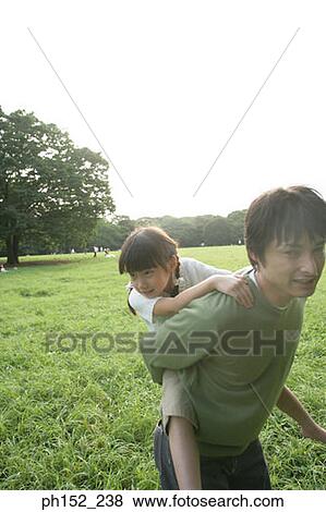 Girl riding piggyback on her father View Large Photo Image Stock Photo - Girl riding piggyback on her father. Fotosearch