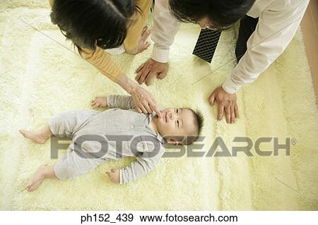 Stock Photo - High angle view of a couple playing with their son. Fotosearch