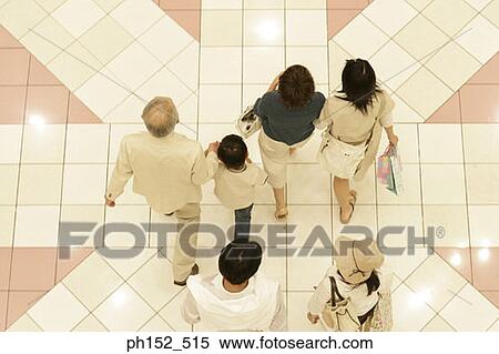Stock Photography - High angle view of a family walking in a shopping mall. Fotosearch