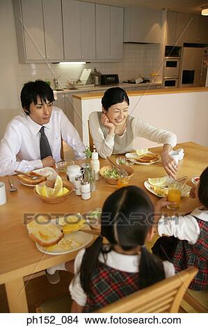 High angle view of a mid adult couple and their daughters at the dining table View Large Photo Image Picture - High angle view of a mid adult couple and their daughters at the dining table. Fotosearch