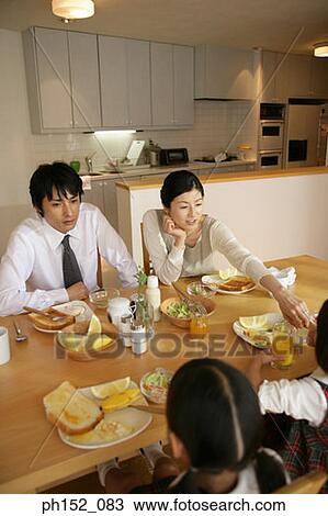High angle view of a mid adult couple and their daughters at the dining table View Large Photo Image Stock Image - High angle view of a mid adult couple and their daughters at the dining table. Fotosearch
