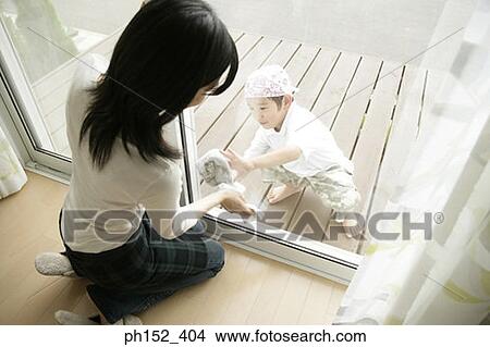 High angle view of a young woman and her son cleaning a window View Large Photo Image Picture - High angle view of a young woman and her son cleaning a window. Fotosearch