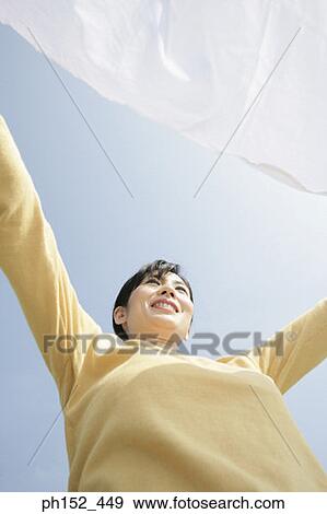 Low angle view of a mid adult woman with her arm outstretched View Large Photo Image Stock Photo - Low angle view of a mid adult woman with her arm outstretched. Fotosearch
