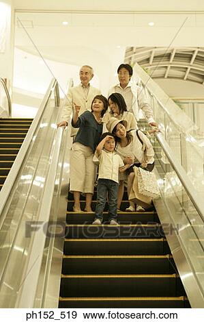 Low angle view of a three generation family on an escalator in a shopping mall View Large Photo Image Stock Photo - Low angle view of a three generation family on an escalator in a shopping mall. Fotosearch