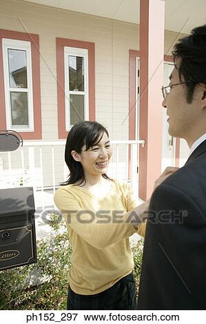 Stock Photo - Mature woman adjusting a mature man's tie and smiling. Fotosearch