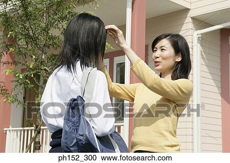Mature woman adjusting her daughter's hair View Large Photo Image Stock Image - Mature woman adjusting her daughter's hair. Fotosearch