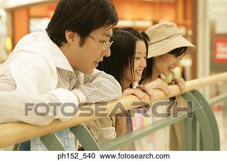 Mid adult couple and their daughter in a shopping mall View Large Photo Image Stock Image - Mid adult couple and their daughter in a shopping mall. Fotosearch