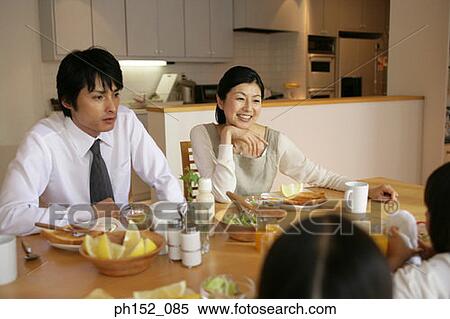 Mid adult couple and their daughters at the dining table View Large Photo Image Stock Photography - Mid adult couple and their daughters at the dining table. Fotosearch