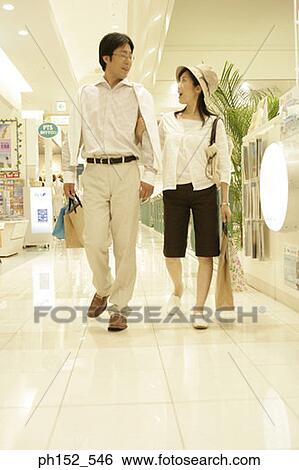 Mid adult couple carrying shopping bags in a shopping mall View Large Photo Image Stock Photograph - Mid adult couple carrying shopping bags in a shopping mall. Fotosearch