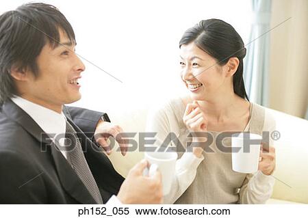 Mid adult couple holding cups of coffee and smiling View Large Photo Image Stock Photography - Mid adult couple holding cups of coffee and smiling. Fotosearch