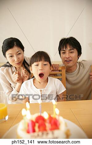Mid adult couple sitting with their daughter in front of a birthday cake View Large Photo Image Stock Image - Mid adult couple sitting with their daughter in front of a birthday cake. Fotosearch