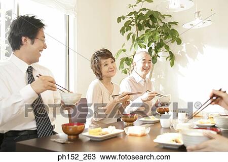 Mid adult man and his parents sitting at a dining table View Large Photo Image Stock Image - Mid adult man and his parents sitting at a dining table. Fotosearch