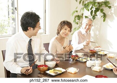 Mid adult man and his parents sitting at a dining table View Large Photo Image Stock Photo - Mid adult man and his parents sitting at a dining table. Fotosearch