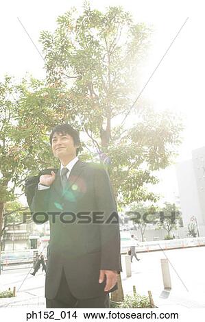 Mid adult man carrying a hand bag and smiling View Large Photo Image Picture - Mid adult man carrying a hand bag and smiling. Fotosearch