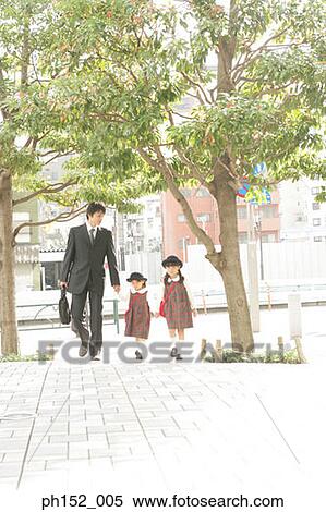 Stock Photography - Mid adult man holding his daughter's hand and walking. Fotosearch